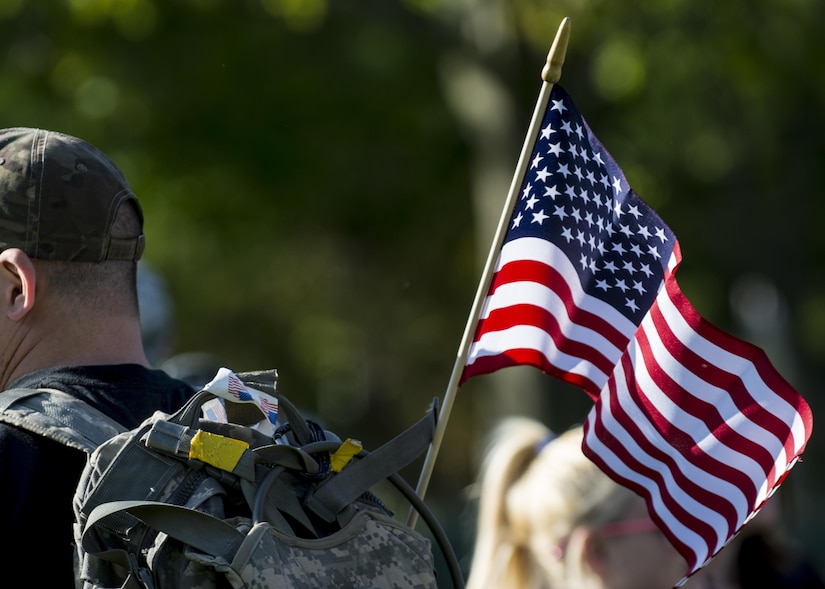 An american flag hangs on the back of a participant during the Chicago Honor the Fallen Ruck March. Approximately 450 military veterans, service members and supporters gathered for a 22-mile ruck march on May 22, just days before Memorial Day, to honor military men and women who suffer from Post-Traumatic Stress Disorder or have committed suicide. (U.S. Army photo by Sgt. 1st Class Michel Sauret)