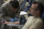 Airman 1st Class Max-Eddie Ibarrientos, 59th Medical Diagnostic and Therapeutic Squadron medical lab technician, starts an I.V. on 2nd Lt. Sol Grosskopf, 502nd Air Base Wing chaplain candidate, July 9, 2015, during a blood drive at JBSA-Randolph. The blood drive was hosted by the 902nd Security Forces Squadron, and will help supply blood to San Antonio Military Medical Center and to troops deployed in combat locations. (U.S. Air Force photo by Airman 1st Class Stormy Archer/Released)