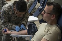 Airman 1st Class Max-Eddie Ibarrientos, 59th Medical Diagnostic and Therapeutic Squadron medical lab technician, starts an I.V. on 2nd Lt. Sol Grosskopf, 502nd Air Base Wing chaplain candidate, July 9, 2015, during a blood drive at JBSA-Randolph. The blood drive was hosted by the 902nd Security Forces Squadron, and will help supply blood to San Antonio Military Medical Center and to troops deployed in combat locations. (U.S. Air Force photo by Airman 1st Class Stormy Archer/Released)