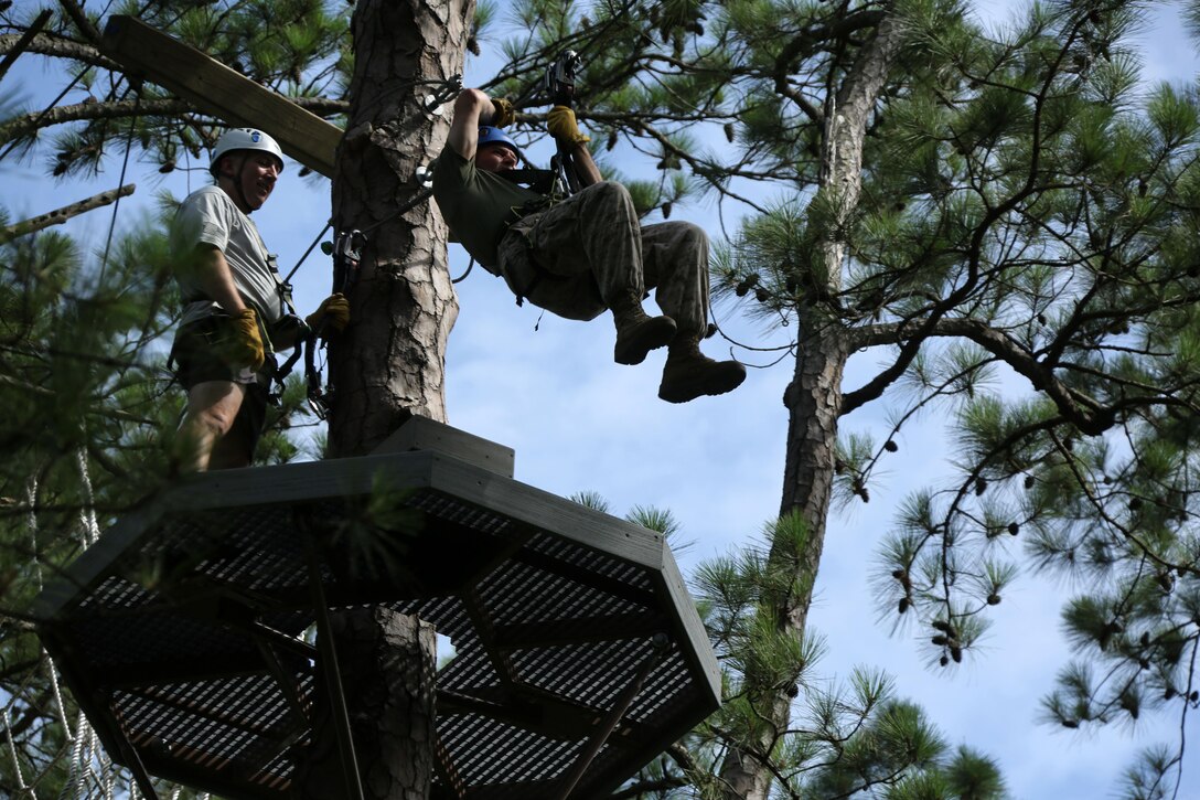 Lt. Col. William Schutz, left, and Maj.David Manka maneuver through obstacles in the tree line while participating in the Devil Dog Dare at Marine Corps Air Station Cherry Point, N.C., July 10, 2015. The Devil Dog Dare is a part of Operation Adrenaline Rush, a Marine Corps-wide program designed to teach Marines how to deal with every day stress in positive ways. Schutz is the commanding officer of Marine Tactical Electronic Warfare Training Squadron 1 and Manka is the commanding officer of Marine Tactical Electronic Warfare Squadron 3. (U.S. Marine Corps photo by Cpl. N.W. Huertas/ Released)