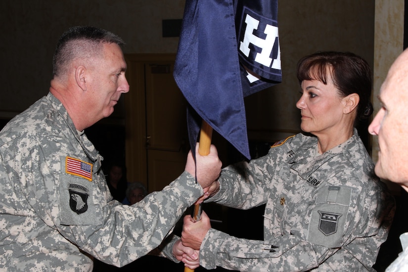 First Sgt. Duane Hedrick, first sergeant of the 76th Operational Response Command Headquarters and Headquarters Company, passes the guidon to Maj. Sandra Peters, outgoing commander of the 76th ORC HHC, during the change of command ceremony held in Salt Lake City, March 15, 2015. During the ceremony, Peters relinquished command of the to Capt. Sunny Griffith, with friends and family in attendance. (U.S. Army photo by Staff Sgt. Kai L. Jensen, 76th Operational Response Command)