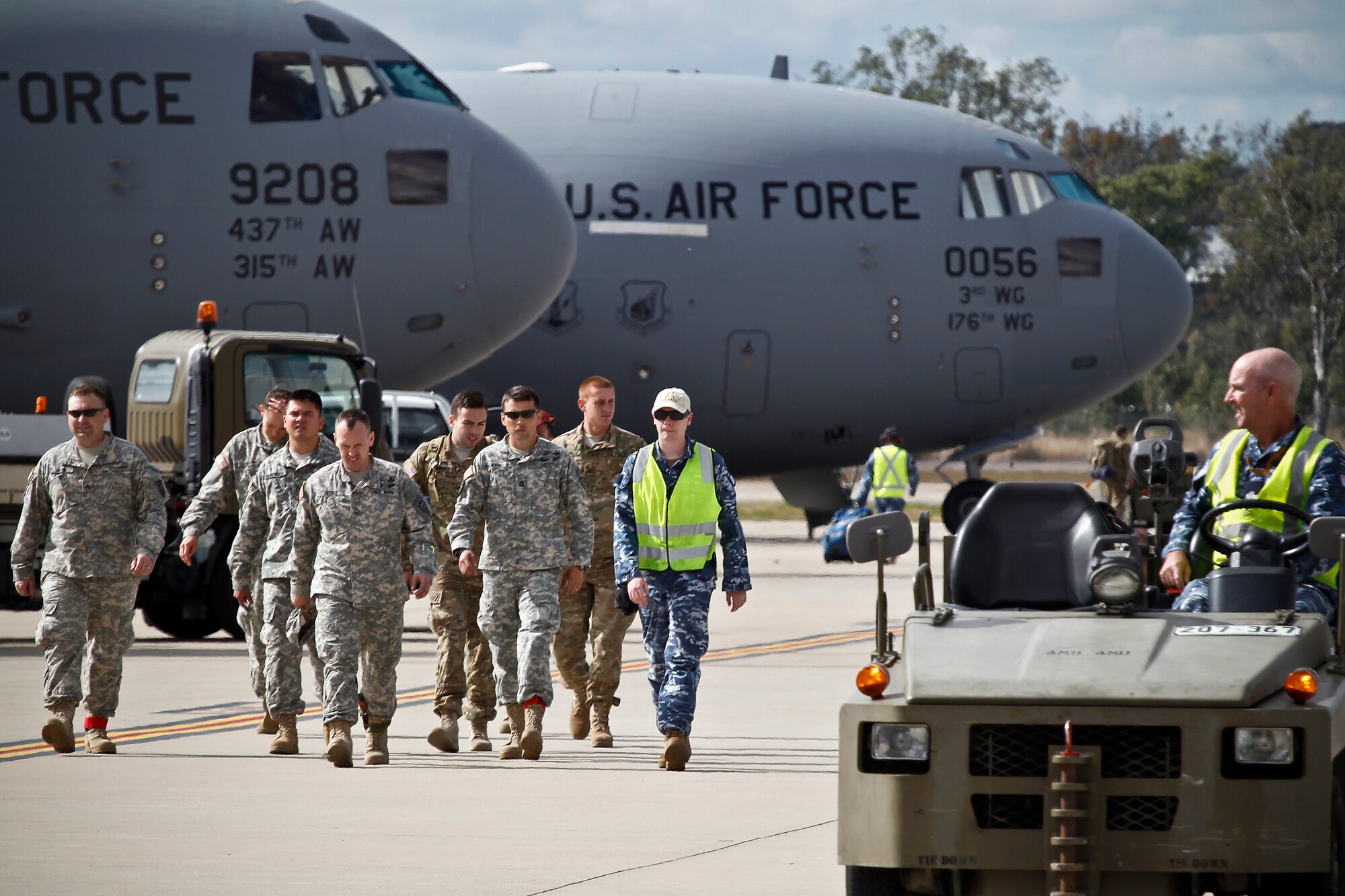 Royal Australian Air Force  personnel escort U.S. military members off the flight line at RAAF Amberley, Australia, after a personnel drop exercise during Talisman Sabre 2015, July 8, 2015. (Royal Australian Air Force photo by Cpl. Peter Borys/Released)