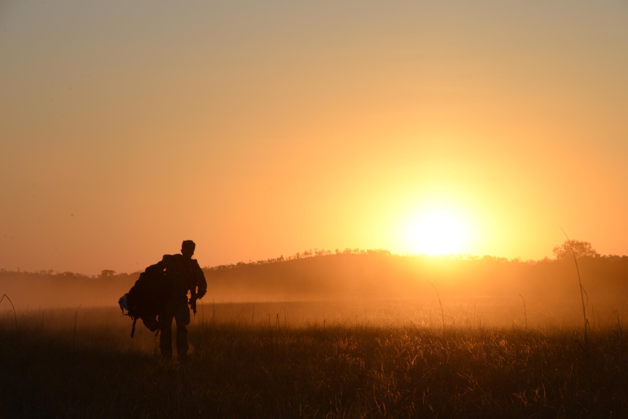 A special tactics special operation weatherman from the 320th Special Tactics Squadron carries his para chute and gear after performing a HALO jump during exercise Talisman Sabre in Northern Territory, Australia, July 10, 2015. Credible, ready maritime forces help to preserve peace and prevent conflict. Talisman Sabre participants have the opportunity to further enhance their ability to respond to crises as part of a joint or combined effort. (U.S. Air Force photo by Senior Airman Stephen G. Eigel)
