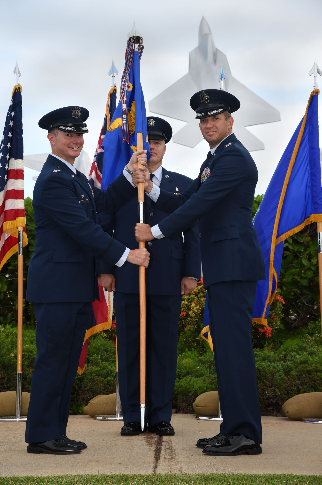 Col. Randy Huiss, 15th Wing commander, passes the 15th Medical Group guidon to Col. Christopher Paige, 15th MDG in-coming commander, during the 15th MDG change of command ceremony on Joint Base Pearl Harbor-Hickam, Hawaii, July 14, 2015. Paige comes to the 15th MDG from Maxwell Air Force Base, where he was a student at the Air War College. As the new MDG Commander, Paige will be responsible for providing medical and dental services for 14,800 beneficiaries and ensuring quality healthcare service for 90,000 outpatient visits, 22,000 dental visits, and over 125,000 pharmaceutical distributions annually. (U.S. Air Force Photo by Tech Sgt. Aaron Oelrich/Released)