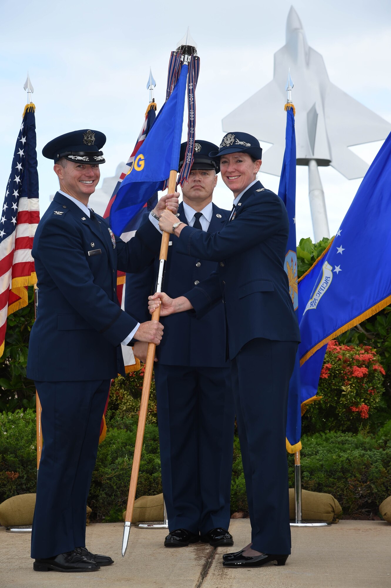 Col. Randy Huiss, 15th Wing commander, receives the 15th Medical Group guidon from Col. Virginia A. Garner, 15th MDG commander during the 15th MDG change of command ceremony on Joint Base Pearl Harbor-Hickam, Hawaii, July 14, 2015. As the 15th MDG commander Garner lead nearly 243 personnel and three squadrons, overseeing a 35 million dollar infrastructure, operations and maintenance budget. During the ceremony, Garner was presented the Legion of Merit for her outstanding service and accomplishments as commander of the 15th MDG. (U.S. Air Force Photo by Tech Sgt. Aaron Oelrich/Released)
