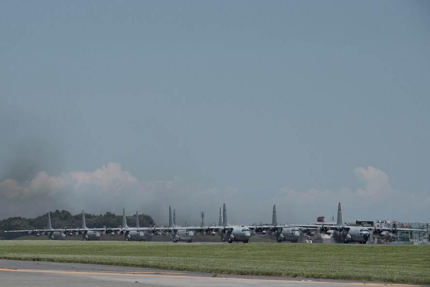 Nine C-130 Hercules prepare to take off during large formation training at Yokota Air Base, Japan, July 14, 2015. The C-130s practiced their large formation and airlift capabilities. (U.S. Air Force photo by Staff Sgt. Cody H. Ramirez/Released)