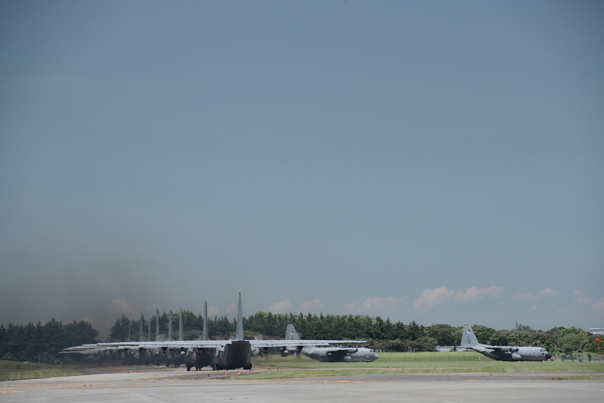 Multiple C-130 Hercules taxi during large formation training at Yokota Air Base, Japan, July 14, 2015. Nine C-130s took off during the training, practicing their large formation and airlift capabilities. (U.S. Air Force photo by Staff Sgt. Cody H. Ramirez/ Released)