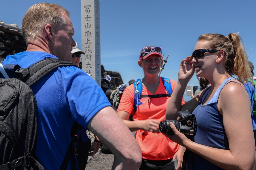 Chief Master Sergeant of the Air Force James A. Cody interacts with Airmen at the summit of Mount Fuji, Japan, July 11, 2015. Cody spent time getting to know many of the hikers, taking time to pose for pictures, sign walking sticks and talk to the Airmen. (U.S. Air Force photo by Airman 1st Class Elizabeth Baker/Released)