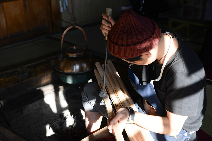 A worker at one of the stations on Mount Fuji, Japan, stamps a hiking stick, July 10,2015. Collecting commemorative stamps on a hiking stick is part of the experience hikers can take home after climbing Fuji. (U.S. Air Force photo by Airman 1st Class Elizabeth Baker/Released)