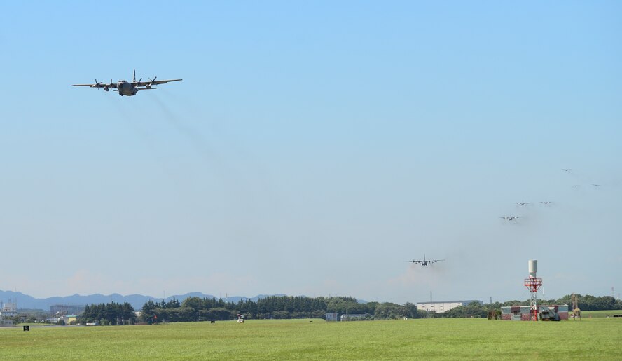 Multiple C-130 Hercules fly over the airfield during a training exercise at Yokota Air Base, Japan, July 14, 2015. Ten C-130s participated in the exercise which tested the 36th Airlift Squadron’s ability to perform large formation flights. (U.S. Air Force photo by Senior Airman David Owsianka/Released)