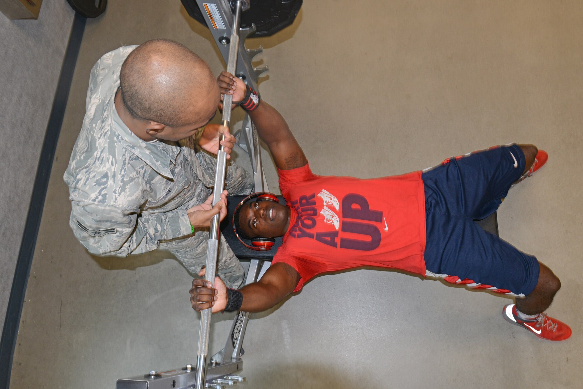 U.S. Air Force Airman 1st Class Lazrus Lee, a 354th Force Support Squadron fitness specialist, spots Senior Airman Dion Edwards, a 354th Logistics Readiness Squadron vehicle maintainer, as he bench presses 205 pounds in the Baker Field House, July 13, 2015, at Eielson Air Force Base, Alaska. Part of Lee’s duties includes providing workouts for customers who need assistance. (U.S. Air Force photo by Senior Airman Ashley Nicole Taylor/Released)