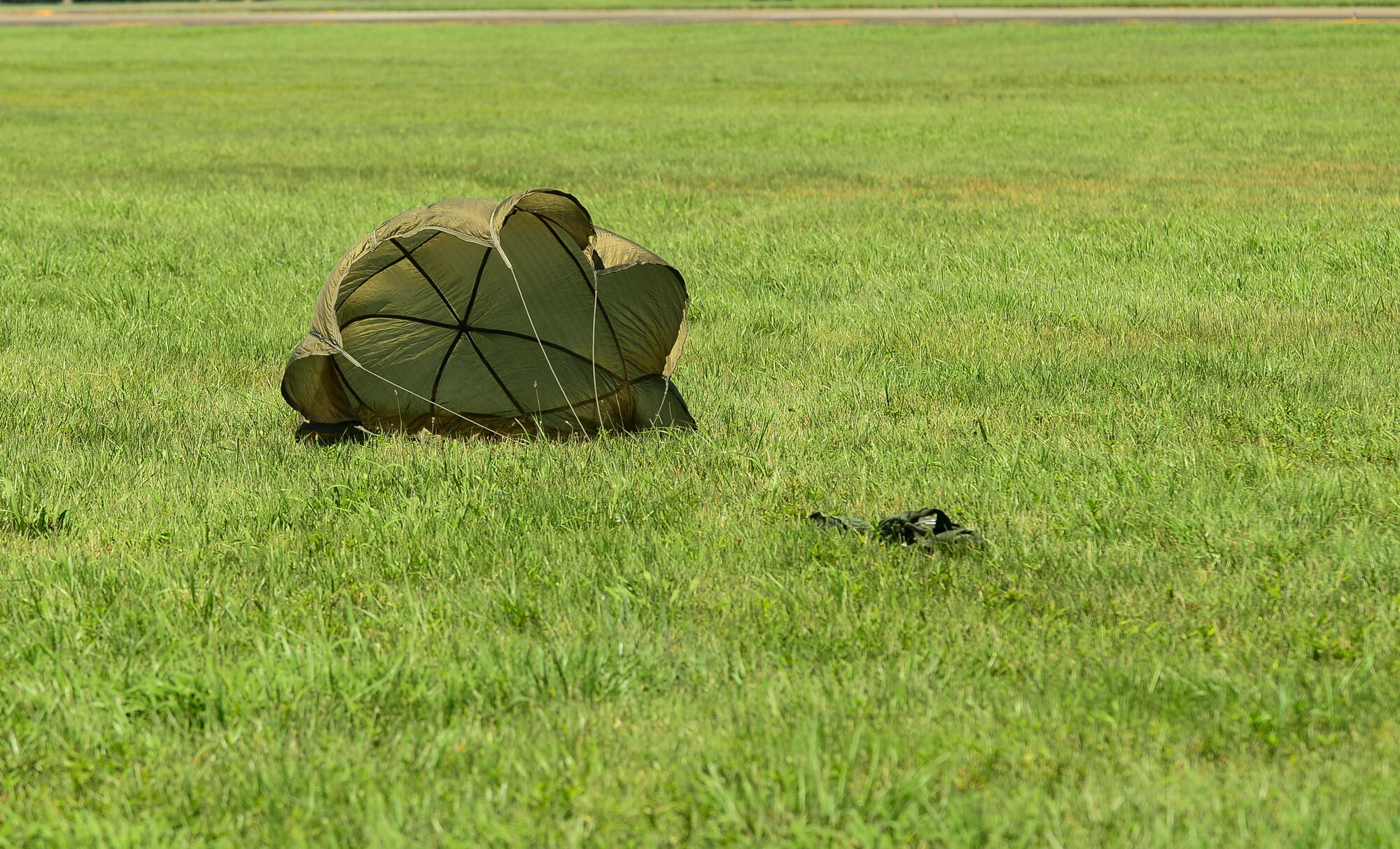 A sandbag hits the ground during a training exercise at Yokota Air Base, Japan, July 14, 2015. This exercise tested the squadron’s ability to accurately drop cargo to a specific target. (U.S. Air Force photo by Senior Airman David Owsianka/Released)