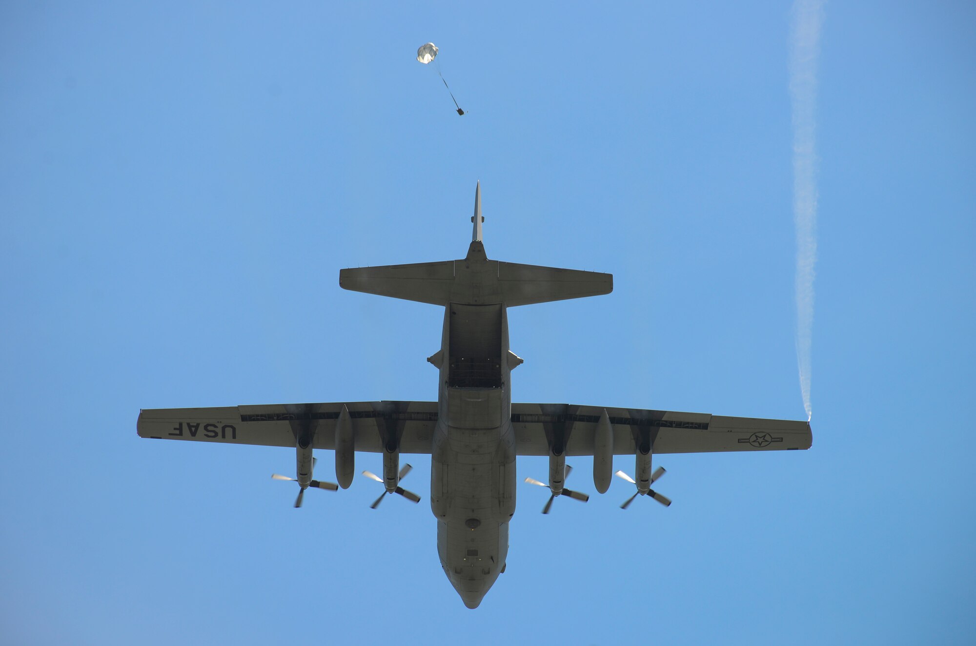 Members of the 36th Airlift Squadron release a sandbag with a parachute from a C-130 Hercules during a training exercise at Yokota Air Base, Japan, July 14, 2015. This exercise tested the squadron’s ability to accurately drop cargo to a specific target. (U.S. Air Force photo by Senior Airman David Owsianka/Released)