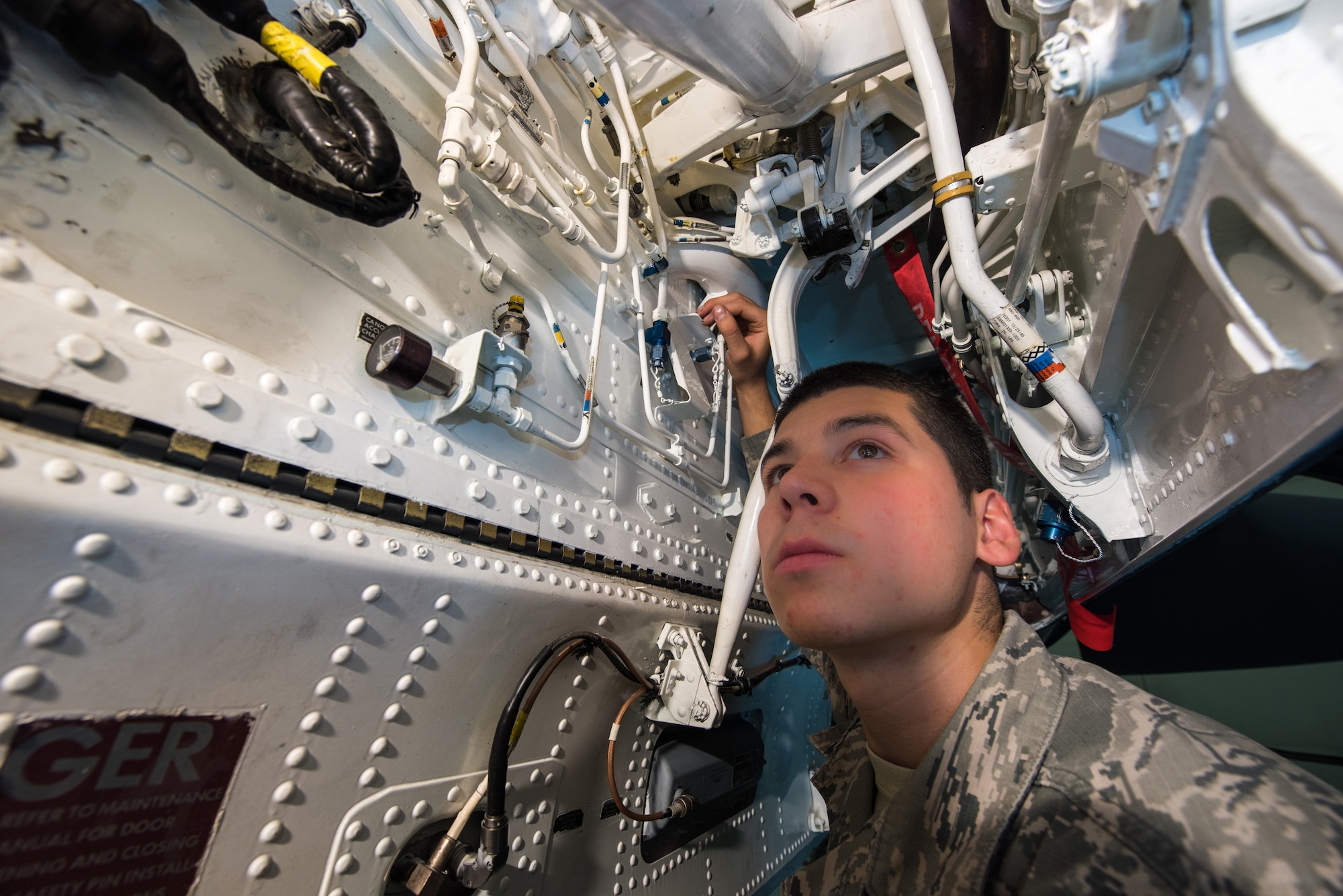 Airman 1st Class Saul Vasquez, 366th Equipment Maintenance Squadron phase inspection team member, poses for a photo inside the front wheel well of an F-15E Strike Eagle at Mountain Home Air Force Base, Idaho, June 25, 2015. The opening, barely larger than a foot wide, is laden with pipes and wires requiring absolute precision to maneuver. A simple misstep caused Vasquez to tear his radial artery on one of the many obstacles inside the belly of the aircraft. (U.S. Air Force photo by Airman 1st Class Connor J. Marth)