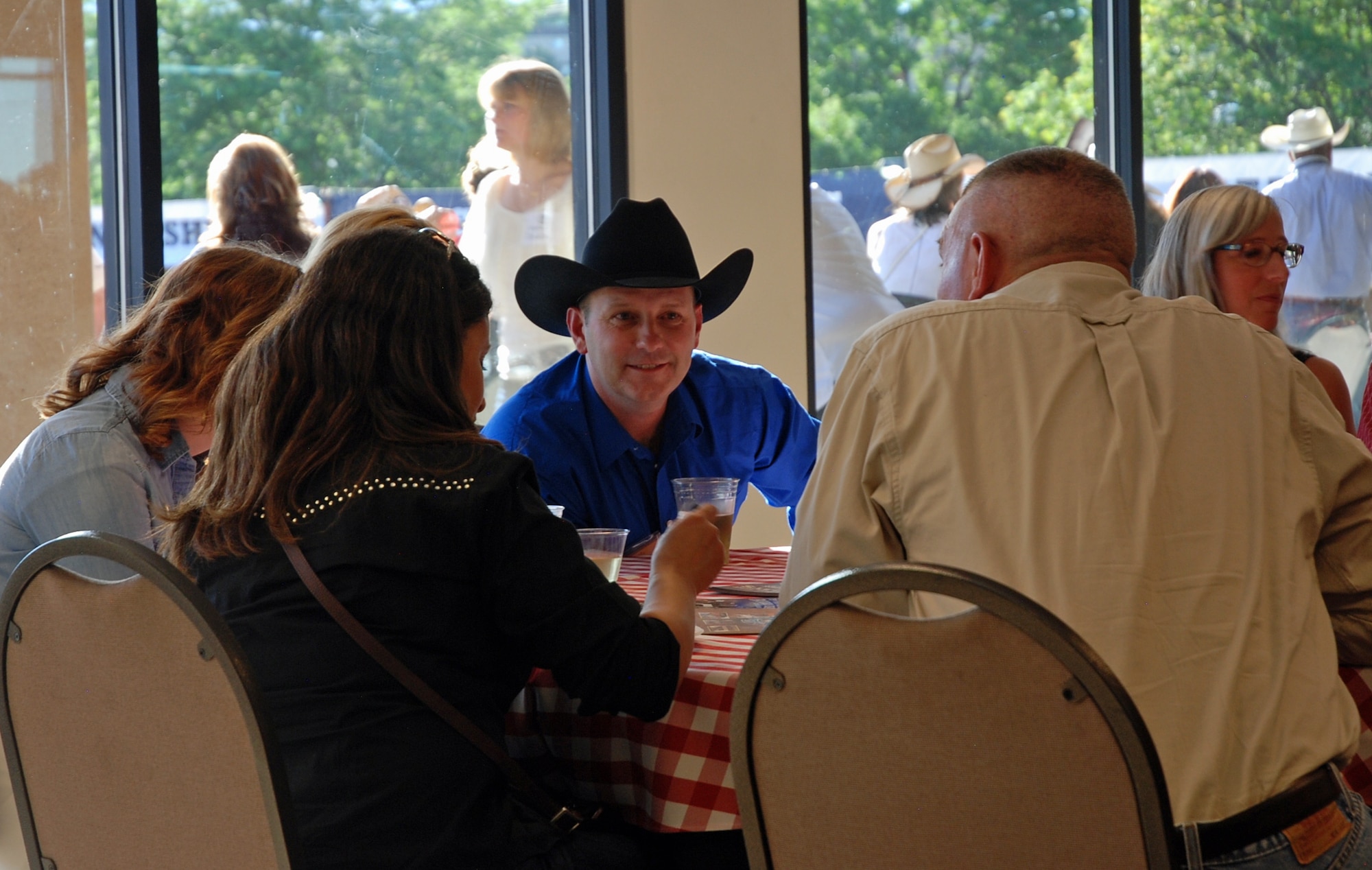 COLORADO SPRINGS, Colo. -- Col. Douglas Schiess, 21st Space Wing commander, talks with tablemates at the 75th Annual Pikes Peak or Bust Rodeo July 10 during Air Force Space Command night. Fifty recipients were selected by local Air Force base commanding officers for their outstanding service to receive a Salute Our Troops challenge coin and recognition during the night’s rodeo opening events. (U.S. Air Force photo by Dave Smith)