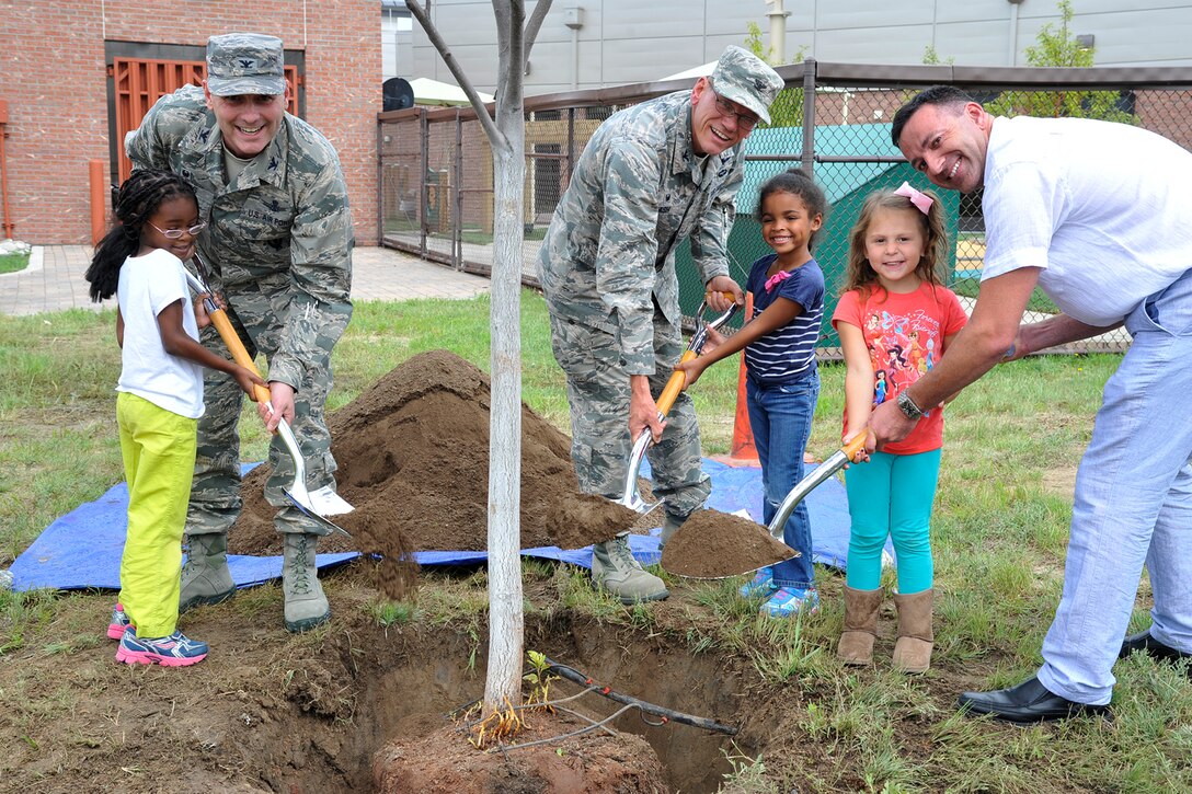 PETERSON AIR FORCE BASE, Colo. – Col. Douglas Schiess, 21st Space Wing commander, celebrates Arbor Day July 8 at the Peterson East Child Development Center by planting three trees on the west side of the building. Joining Schiess to plant the trees are Col. Reggie Ash, 21st Mission Support Group commander, Fred Brooks, 21st Civil Engineer Squadron Environmental Element chief, Kathryn Walton, Cori Parker and Khloe Vargas. Schiess also accepted the Tree City USA Growth Award presented by the Arbor Day Foundation, which recognizes excellence in urban forestry management. The award has been given to Peterson AFB for 21 consecutive years. (U.S. Air Force photo by Robb Lingley)