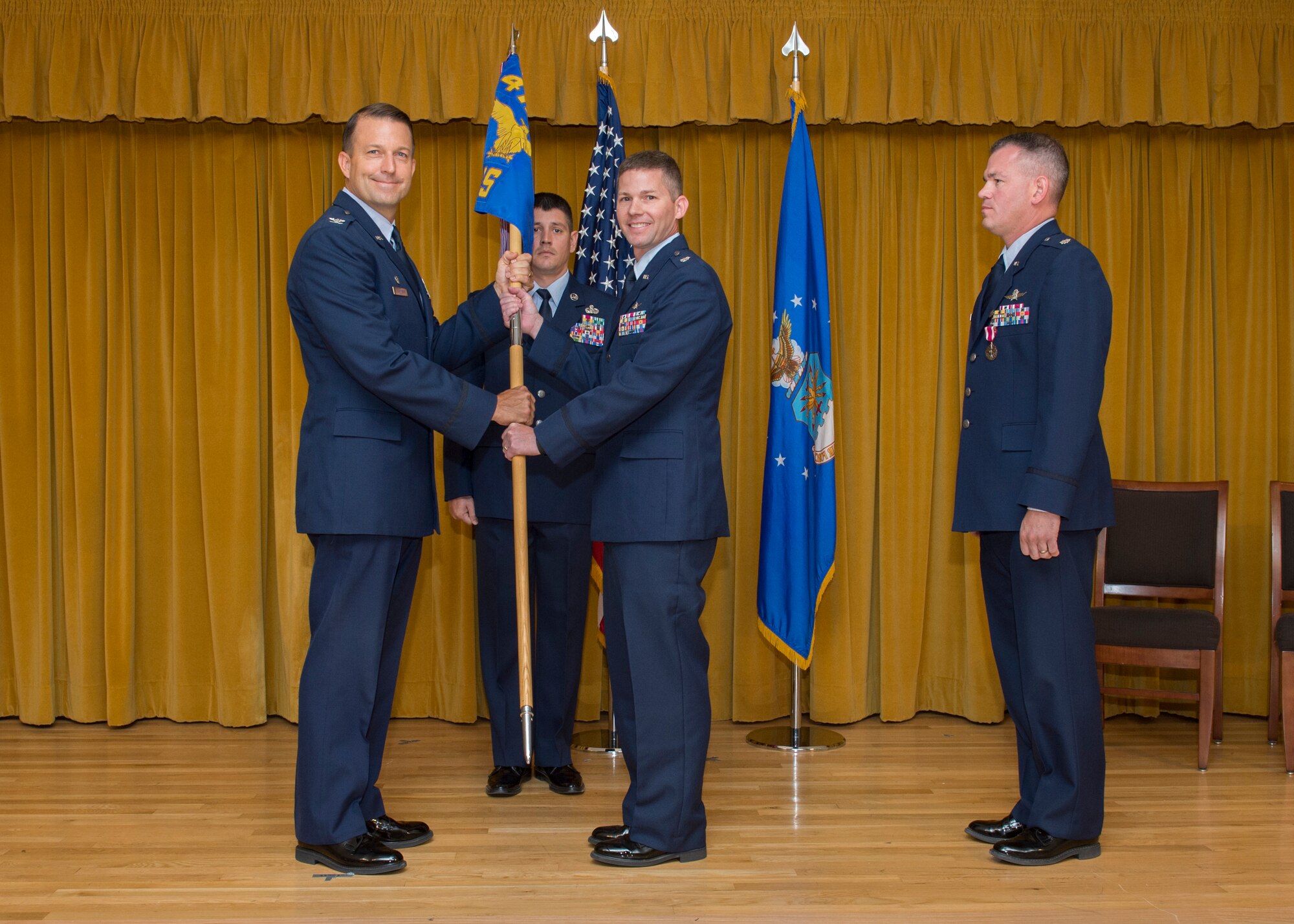 From left: Col. Eric Leshinsky, 412th Mission Support Group commander, and Lt. Col. J. Scott Fuller pose for a photo as Lt. Col. Christopher Budde looks on. Budde relinquished command of the 412th Communications Squadron to Fuller during a change of command ceremony at Club Muroc July 10. (U.S. Air Force photo by Edward Cannon)