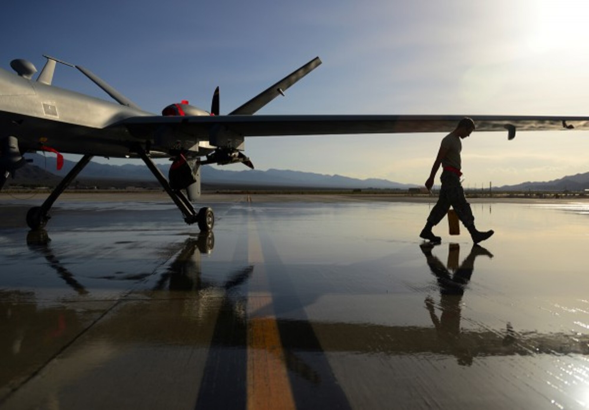 A remotely piloted aircraft maintainer assigned to the 432nd Aircraft Maintenance Squadron removes wheel chalks from a MQ-9 Reaper after a training mission at Creech Air Force Base, Nevada. Aircraft maintainers and pilots work together to greet the aircraft upon each landing. (U.S. Air Force photo by Staff Sgt. Vernon Young Jr.)