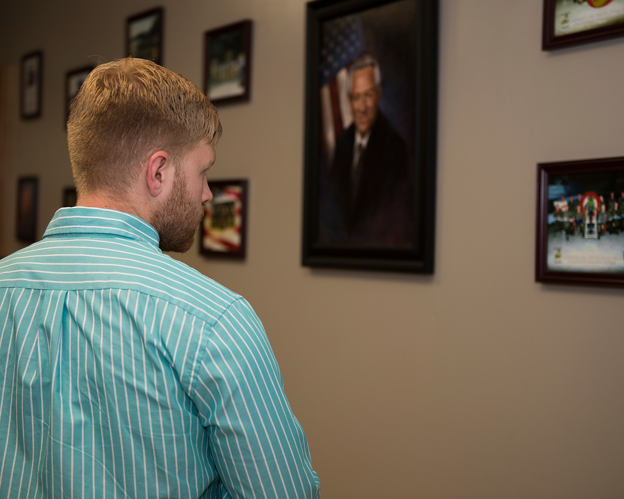 Colton Whitt, grandson of Kent “Doc” Salvage, looks at the photos of his grandfather after a room dedication ceremony to honor his service and sacrifice to the 363rd Training Squadron at Sheppard Air Force Base, Texas, July 14, 2015. Salvage passed away due to a heart attack and is buried in Arlington National Cemetery, Va. (U.S. Air Force photo by Senior Airman Kyle Gese/Released)