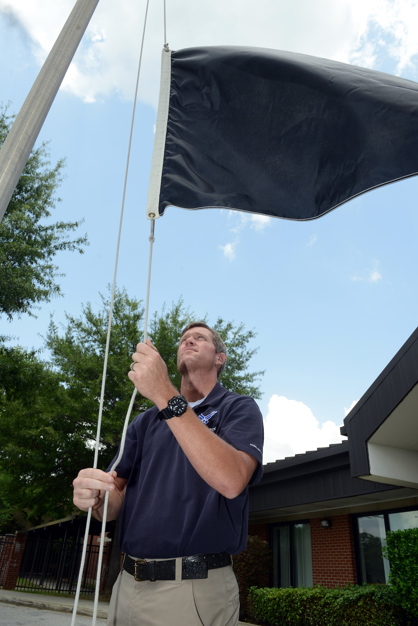 Patrick Stone, 78th Air Base Wing recreation assistant, raises the black flag indicating outdoor heat conditions at Robins. White, green, yellow, red and black flags are used to alert those outside of the current heat index. (U.S. Air Force photo by Tommie Horton) 