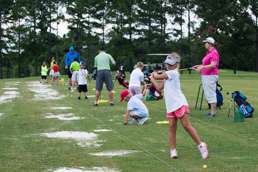 Children hit golf balls at the Quiet Pines Golf Course driving range during the QP Summer Golf League July 9, 2015, at Moody Air Force Base, Ga. Children participating in the golf league practiced on the range before playing on the course. (U.S. Air Force photo by Airman 1st Class Kathleen D. Bryant/Released)

