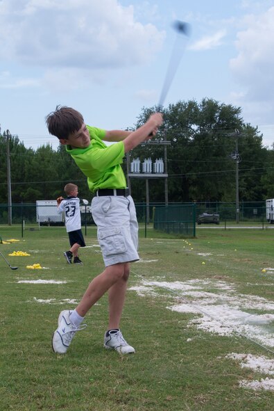 Ethan, son of U.S. Air Force Chaplain (Capt.) Todd Leathermon, 93d Air Ground Operations Wing chaplain, hits a golf ball during the Quiet Pines Summer Golf League July 9, 2015, at Moody Air Force Base, Ga. During the camp, golf coaches worked with the children on their form. (U.S. Air Force photo by Airman 1st Class Kathleen D. Bryant/Released)
