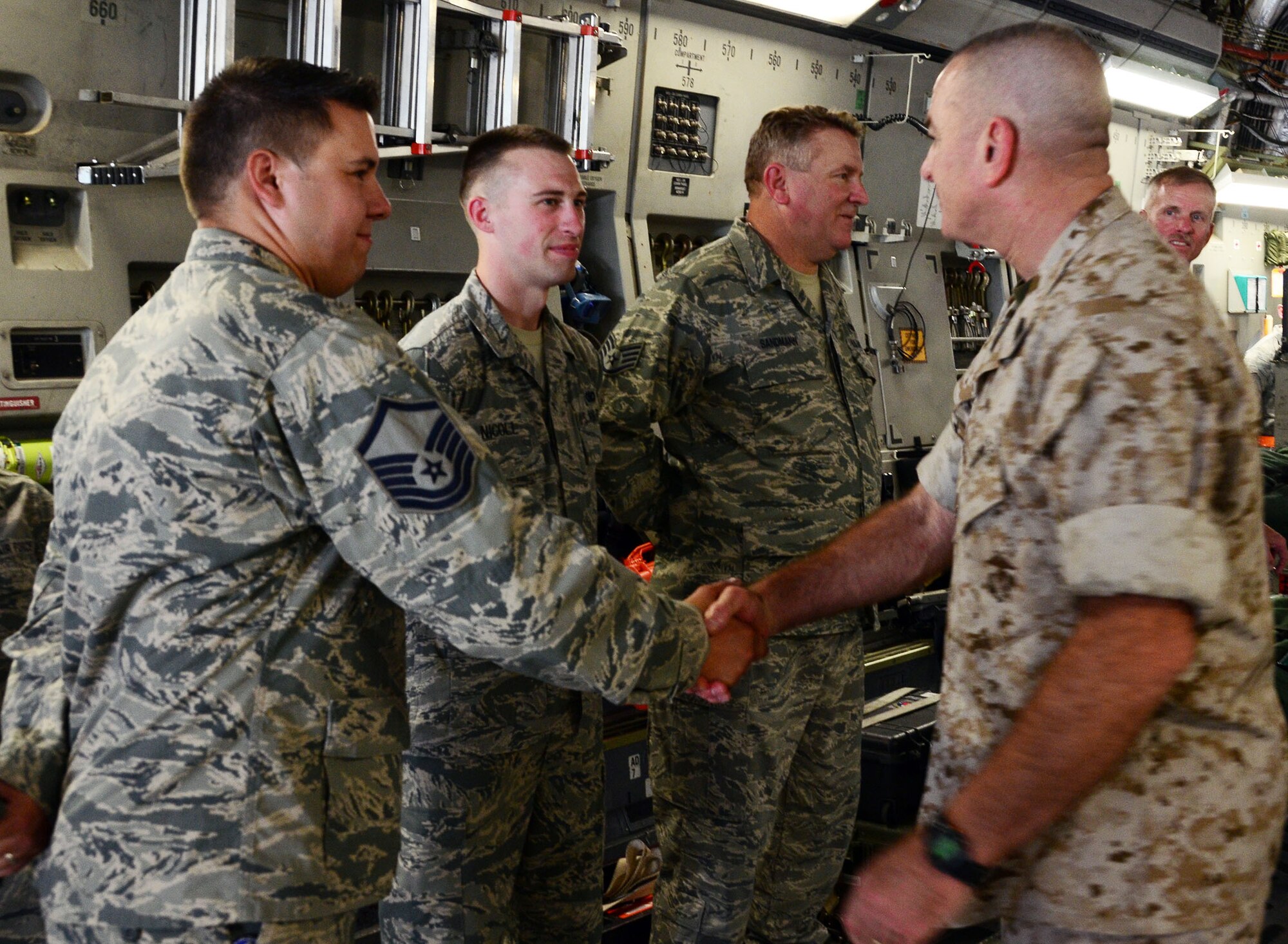 WRIGHT-PATTERSON AIR FORCE BASE, Ohio – Marine Corps Sgt. Maj. Bryan B. Battaglia, the senior enlisted advisor to the chairman of the Joint Chiefs of Staff, is greeted by Master Sgt. Joseph Valenzuela, 445th Aeromedical Evacuation Squadron NCO in charge of inflight medical care, and Senior Airman Peter Nicoll, 445th Security Forces Squadron SF journeyman, during his visit to the 445th Airlift Wing July 11, 2015. While at the wing, Battaglia toured a C-17 Globemaster III, participated in demonstrations by the 445th AE and Aeromedical Staging Squadrons and watched the 87th Aerial Port Squadron load cargo on the aircraft during a training scenario. (U.S. Air Force photo/Senior Airman Joel McCullough)