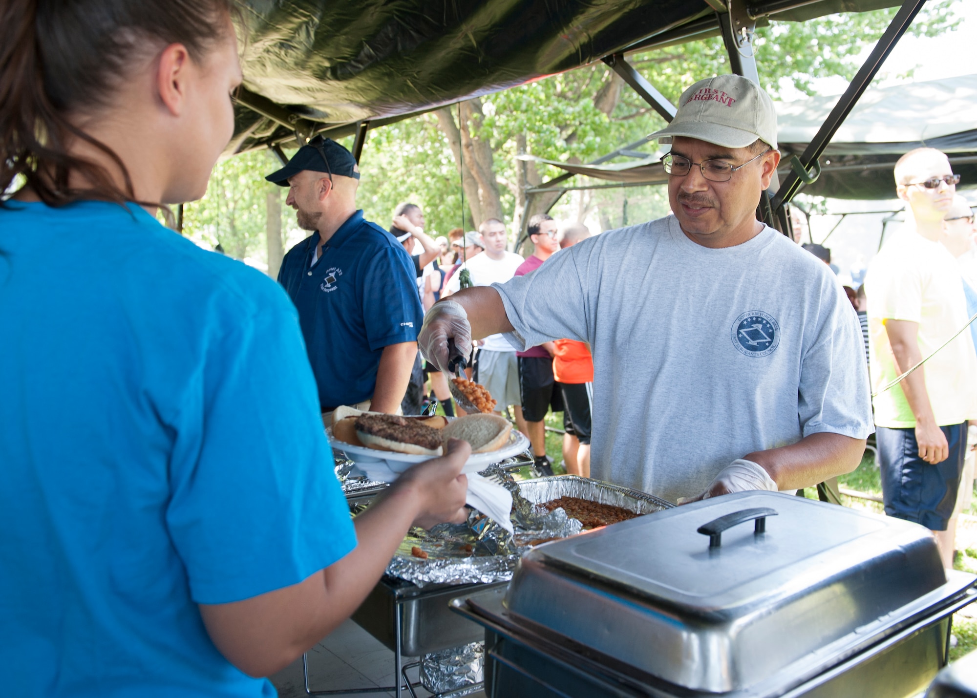 Roland Balik, 436th Airlift Wing Public Affairs photojournalist, serves beans during the 436th AW’s Wingman Day picnic July 10, 2015, at Eagle’s Nest Park on Dover Air Force Base, Del. Balik, a retired master sergeant, formerly served as a first sergeant. (U.S. Air Force photo/Airman 1st Class Zachary Cacicia)