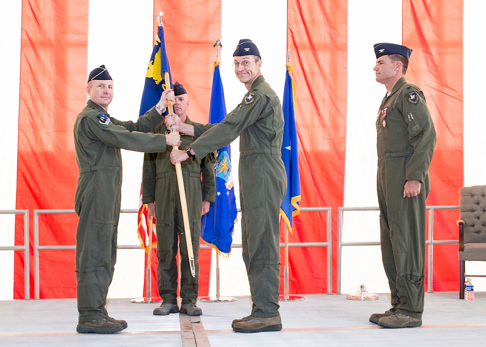 From left: Brig. Gen. Carl Schaefer, 412th Test Wing commander, and Col. Scott Cain, 412th Operations Group commander, pose for a photo with the 412th OG guidon as Col. Rodney Todaro looks on. Cain assumed command of the group July 1 from Todaro. (U.S. Air Force photo by Edward Cannon)
