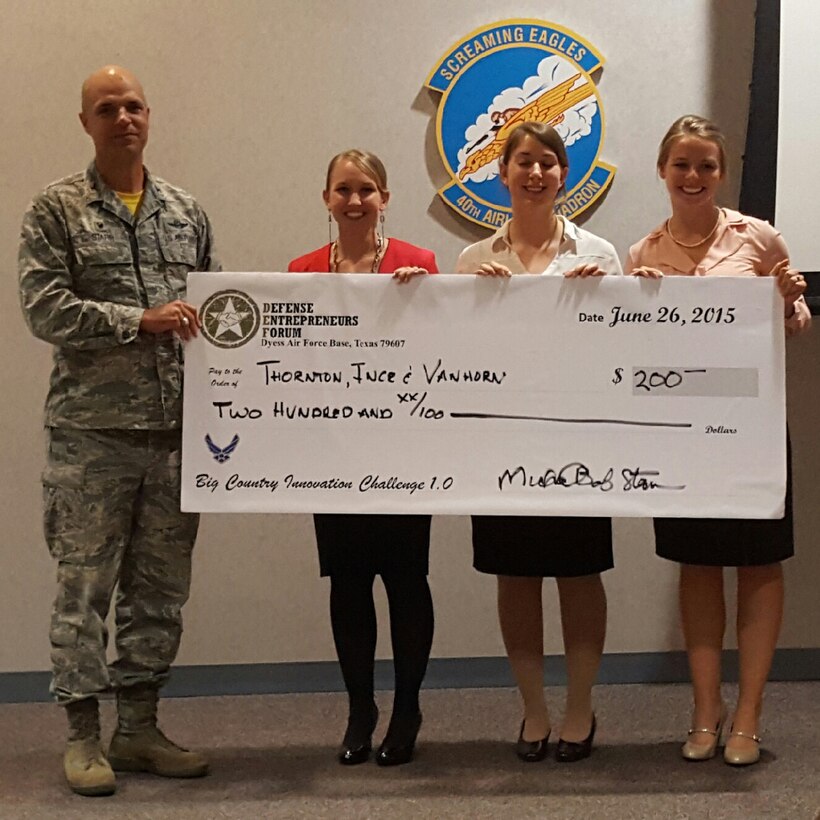 U.S. Air Force Col. Michael Bob Starr, 7th Bomb Wing commander, presents a check to 1st Lt. Erika Thornton, left, 2nd Lt. Megan VanHorn and 1st Lt. Hilary Ince, all assigned to the 7th Contracting Squadron, during the 2015 Big Country Innovation Challenge June 26, 2015, at Dyess Air Force Base, Texas. The Airmen placed first in the competition for their idea to convert hard-copy contracts to electronic contracts permanently within their squadron. (U.S. Air Force photo by 1st Lt. Nicole Ferrara/Released)

