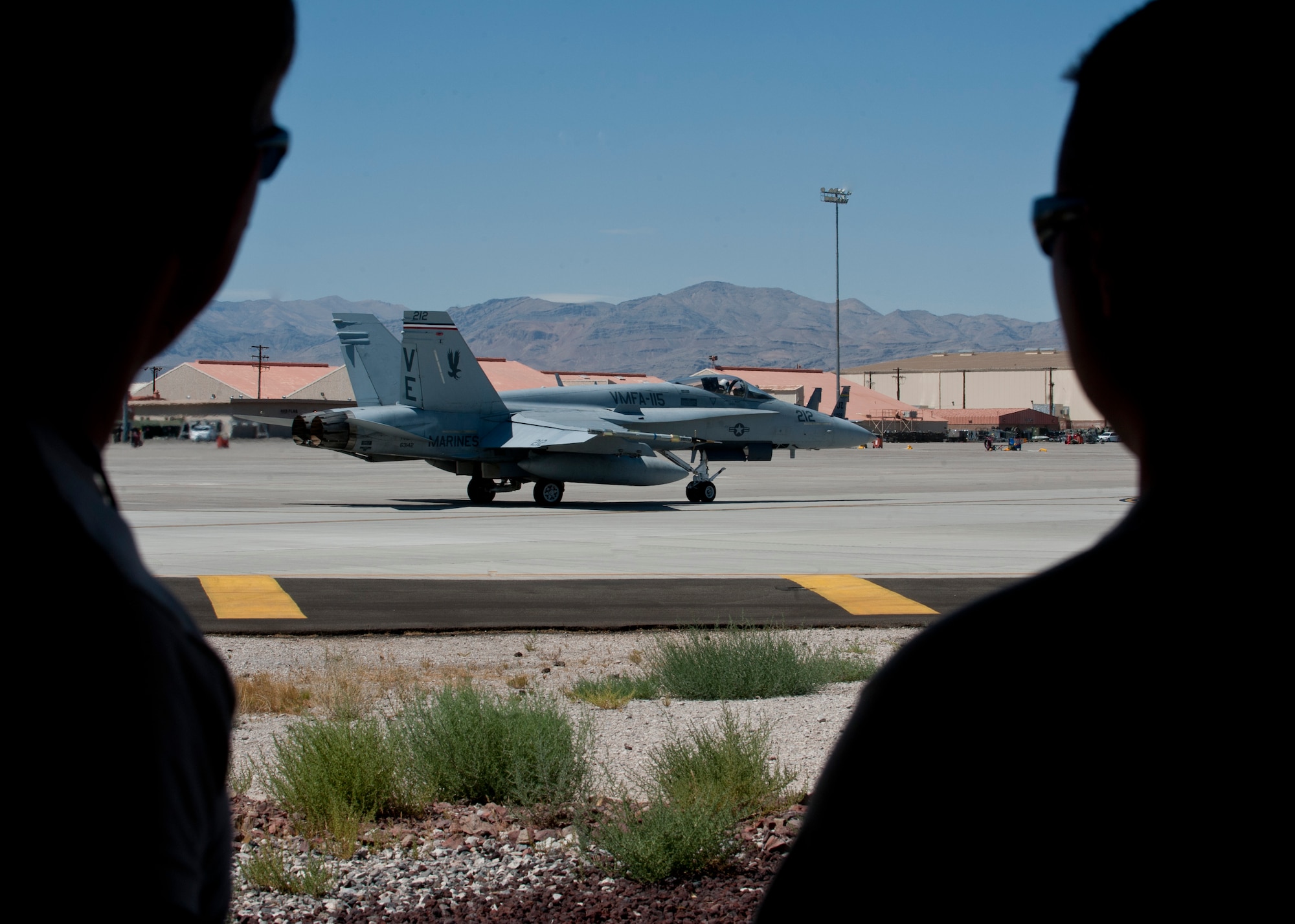 Two maintainers from the 20th Aircraft Maintenance Squadron, Shaw Air Force Base, S.C., watch an F/A-18C Hornet taxi during Red Flag 15-03 at Nellis Air Force Base, Nev., July 13, 2015. Red Flag involves a variety of attack, fighter, bomber, reconnaissance, electronic warfare, airlift support and search and rescue aircraft. (U.S. Air Force photo by Airman 1st Class Jake Carter)