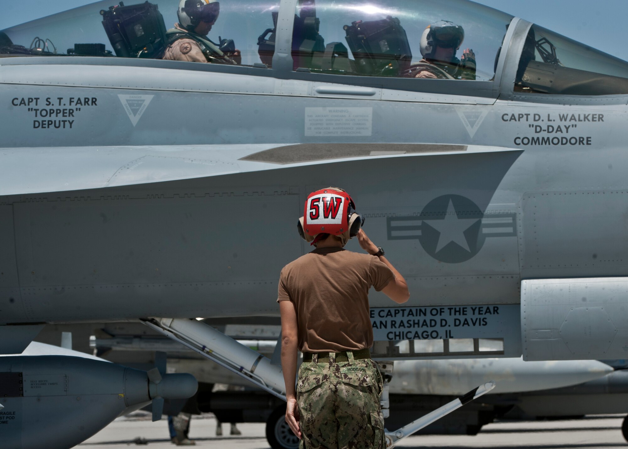 U.S. Navy Aviation Ordnance Airman Lauren Hodgson, Electronic Attack Squadron 138, salutes operators of an EA-18G Growler before a Red Flag 15-03 sortie at Nellis Air Force Base, Nev., July 13, 2015. Red Flag’s mission is to maximize the combat readiness, capability and survivability of participating units by providing realistic training in a combined air, ground, space and electronic threat environment while providing free exchange of ideas between forces. (U.S. Air Force photo by Airman 1st Class Jake Carter)
