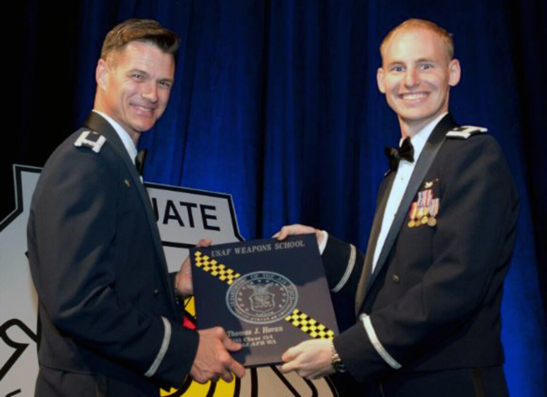 Capt. Thomas Horan, 349th Air Refueling Squadron A-Flight commander, receives his Weapons Schools diploma, June 27, at Nellis Air Force Base, Nev. Horan has been selected for weapons officer crossflow to the KC-10. (Courtesy photo)