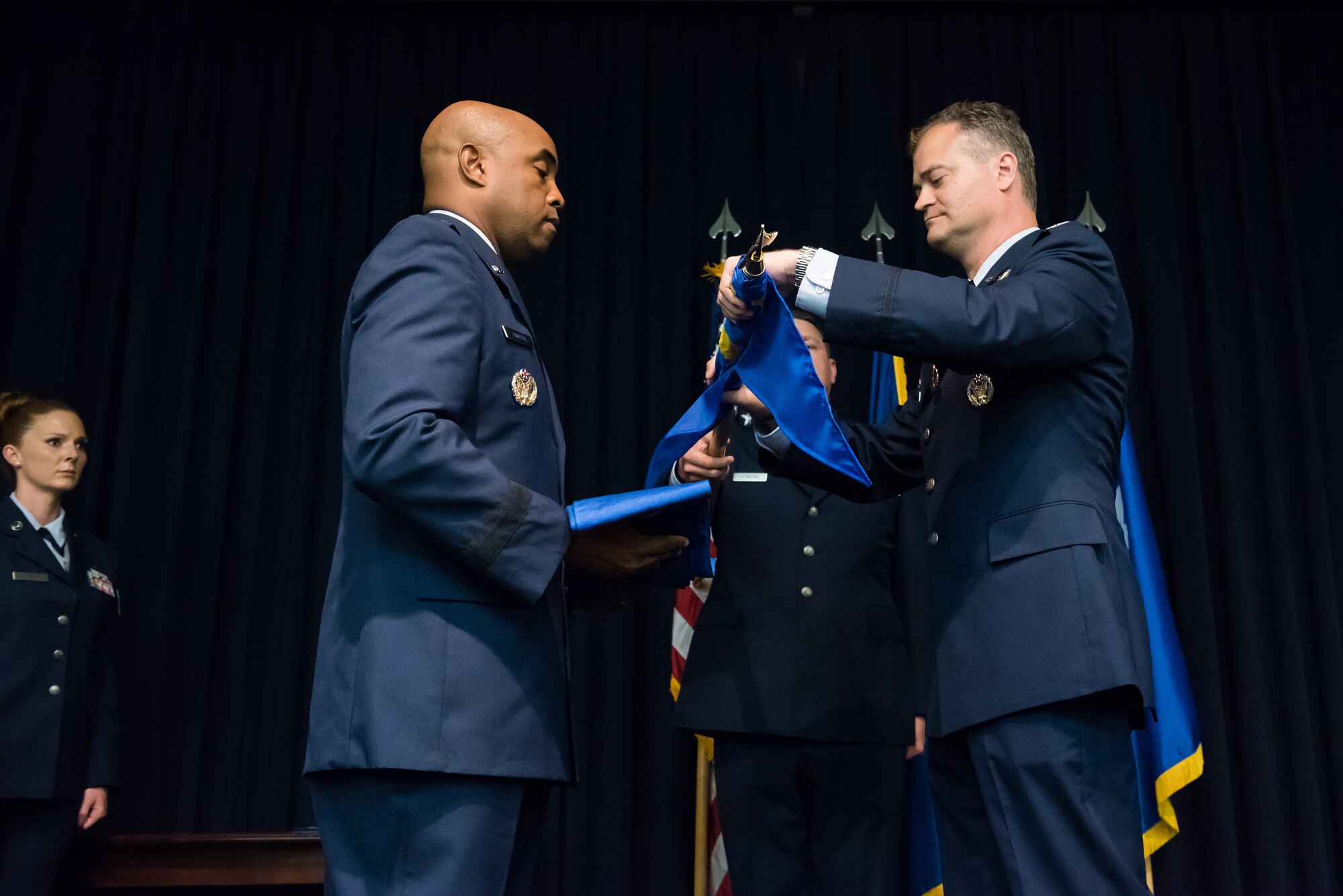 Brig. Gen. Trent Edwards, 37th Training Wing commander, Joint Base San Antonio-Lackland, Texas, prepares to sheath a guidon from Col. Steven Cabosky, Air Advisor Academy commandant, during an inactivation ceremony in the Air Advisor Academy at Joint Base McGuire-Dix-Lakehurst, N.J., July 10, 2015. The U.S. Air Force Expeditionary Center officially assumed the responsibility of being the Air Force's sole provider of training for general purpose force Air Advisors. (U.S. Air Force photo by Russ Meseroll/Released)