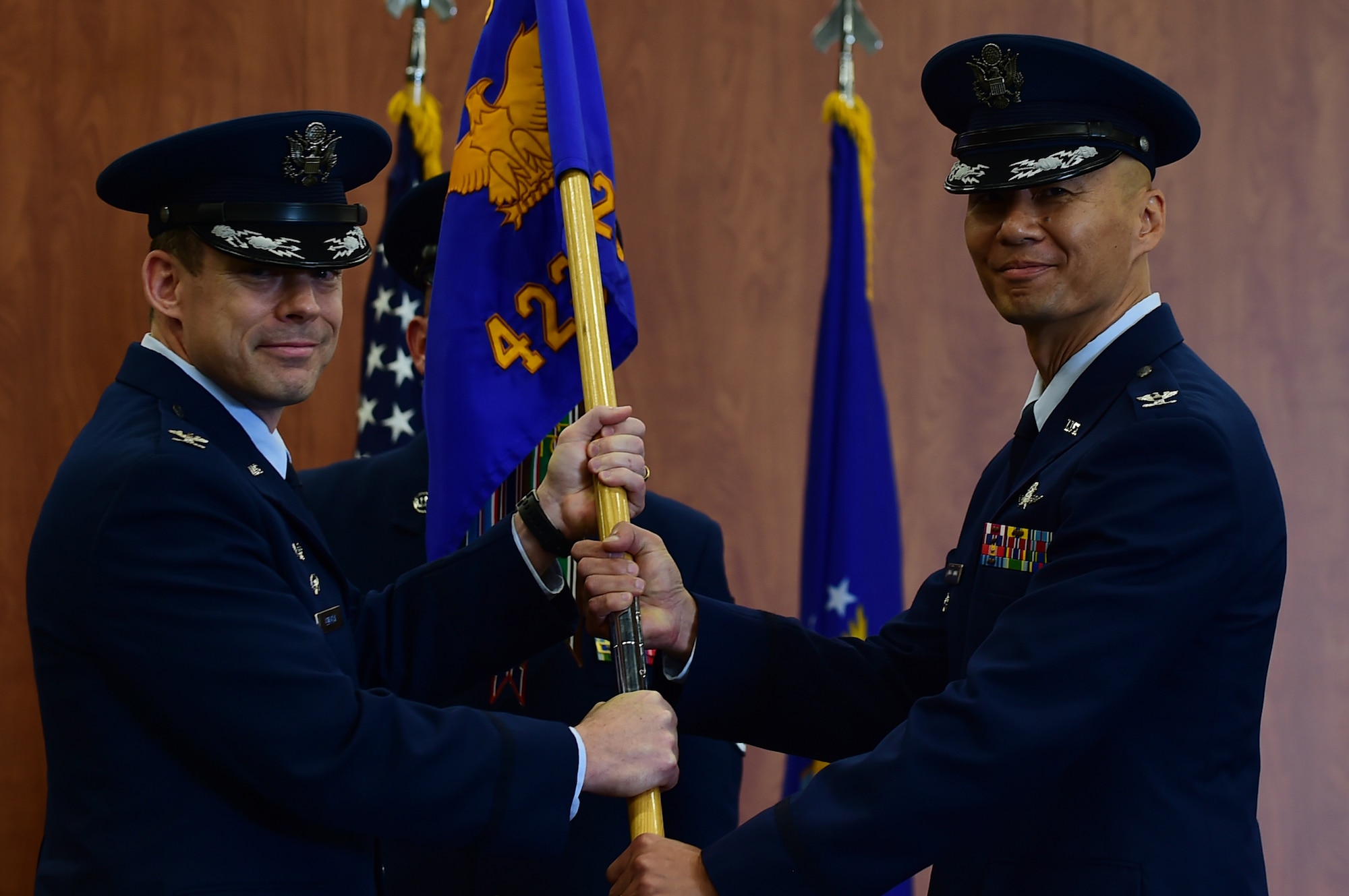 Col. Kevin Cullen, 501st Combat Support Wing commander, passes the 423rd Air Base Group guidon to Col. Young Yu, during a ceremony at RAF Molesworth, United Kingdom, July 14, 2015. Yu assumed command of the 423rd ABG immediately following Col. Steven Sweeney relinquishing command. (U.S. Air Force photo by Tech. Sgt. Chrissy Best)