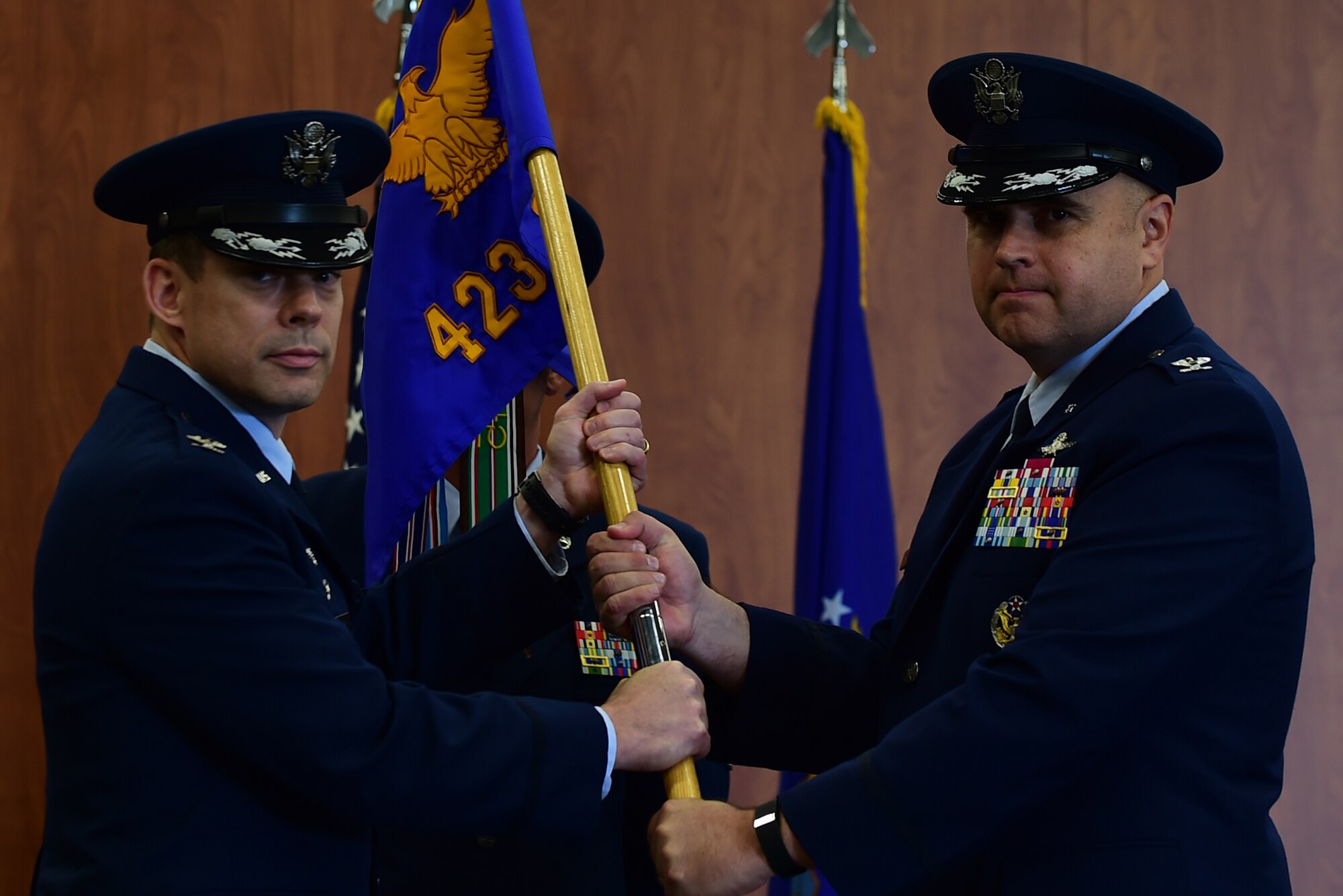 Col. Kevin Cullen, 501st Combat Support Wing commander, passes the guidon to Col. Steven Sweeney to symbolize relinquishing command of the 423rd Air Base Group during a ceremony at RAF Molesworth, United Kingdom, July 14, 2015. Sweeney served as the commander of the 423rd ABG from 2013 until 2015.  (U.S. Air Force photo by Tech. Sgt. Chrissy Best/Released)