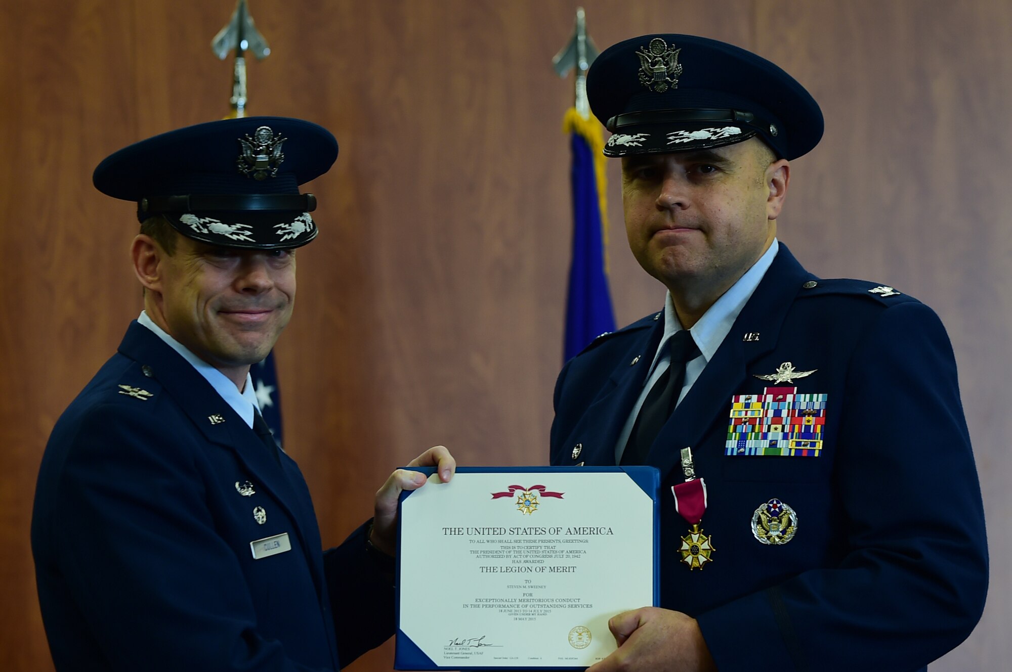Col. Kevin Cullen, 501st Combat Support Wing commander, presents Col. Steven Sweeney, with the Legion of Merit decoration, during the 423rd Air Base Group change of command ceremony at RAF Molesworth, United Kingdom, July 14, 2015, for his exemplary service as commander of the 423rd ABG. Sweeney served as the commander of the 423rd ABG from 2013 until 2015. (U.S. Air Force photo by Tech. Sgt. Chrissy Best/Released)