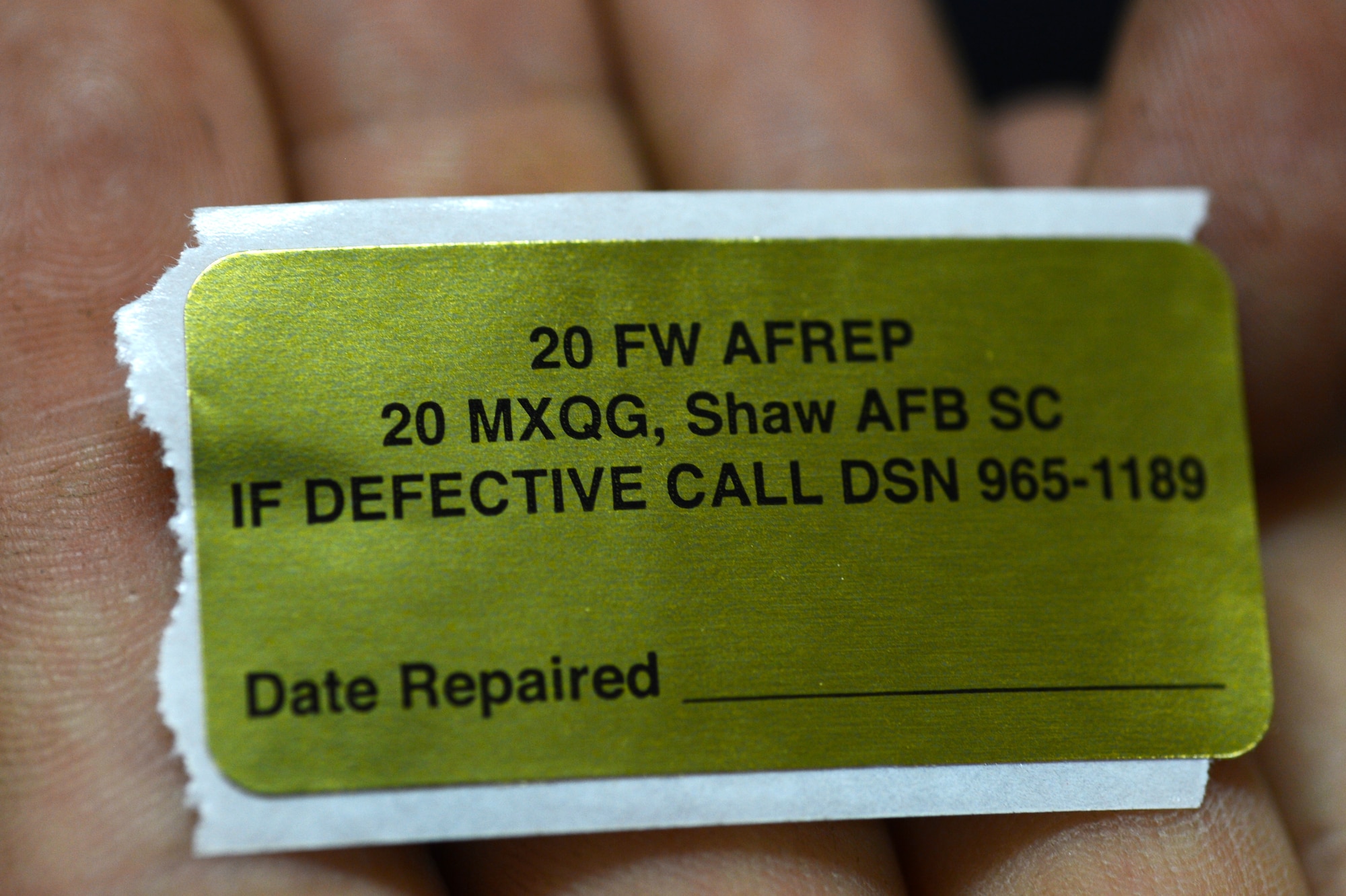 The 20th Maintenance Group’s Air Force Repair Enhancement Program technician holds an AFREP sticker for repaired equipment at Shaw Air Force Base, S.C., June 3, 2015. The Airmen use their maintenance skills to strip wires, solder electronics, and replace broken components to help achieve the mission. (U.S. Air Force photo by Senior Airman Jonathan Bass/Released)