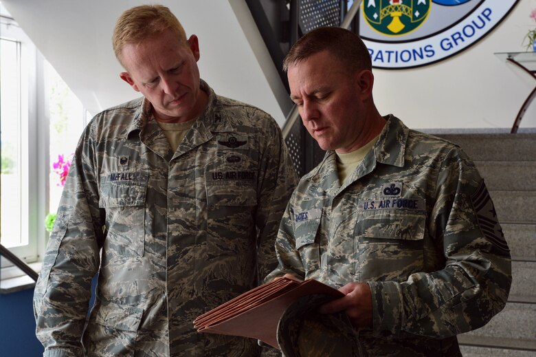 U.S. Air Force Col. Joe McFall, 52nd Fighter Wing commander, and Chief Master Sgt. Brian Gates, 52nd Fighter Wing command chief, discuss their findings during the Dorm of the Quarter competition at Spangdahlem Air Base, Germany, July 8, 2015. The commander and command chief will reveal the final Dorm/Room of the Quarter winners later this month at the Brick House. (U.S. Air Force photo by 2nd Lt Meredith Mulvihill/Released)