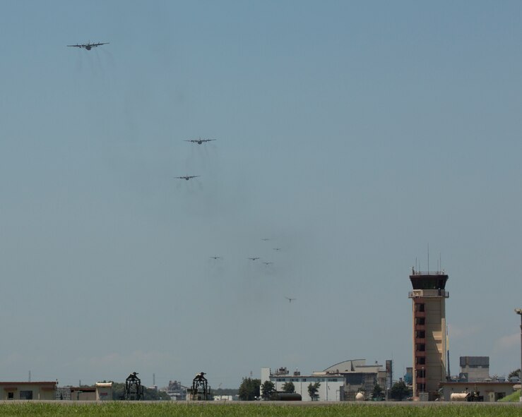 C-130 Hercules aircraft fly over Yokota Air Base, Japan, July 14, 2015. Nine C-130s flew in formation to practice airlift tactics and procedures. (U.S. Air Force photo by Osakabe Yasuo/Released)