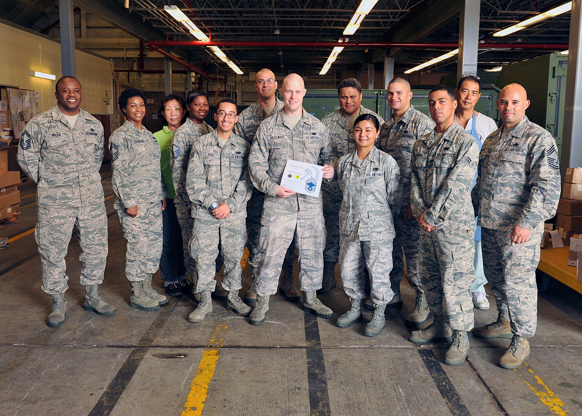 U.S. Air Force Chief Master Sgt. Tammy Cleveland, 18th Logistics Readiness Squadron superintendent, presents the Chief's Choice Award to Senior Airman Jonathon Hazelwood, 18th LRS North aircraft parts store journeyman, during a recognition ceremony on Kadena Air Base, Japan, July 13, 2015. Hazelwood was nominated for his outstanding professionalism, customs, courtesies, bearing and civic contributions to Kadena and the local community. (U.S. Air Force photo by Naoto Anazawa)