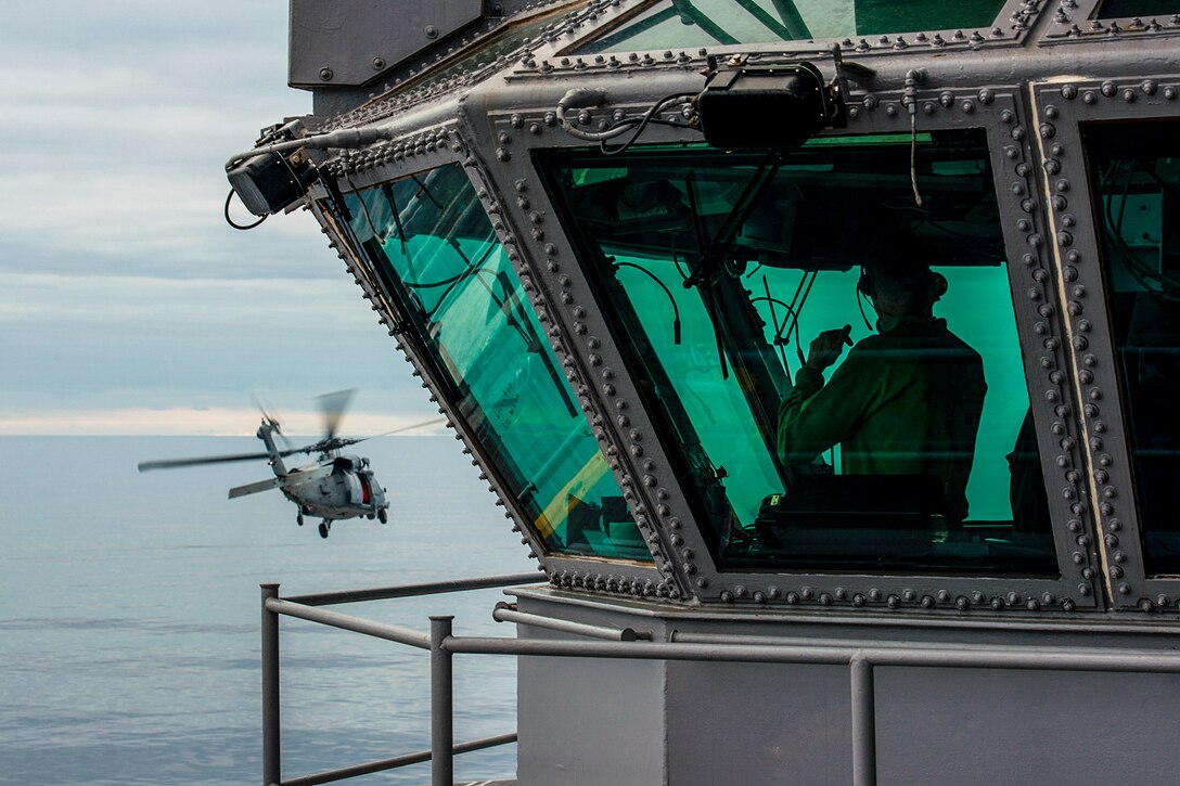 U.S. Navy Cmdr. Darren Guenther uses a public announcement system to communicate with sailors during an ammunition transfer on the USS John C. Stennis in the Pacific Ocean, July 12, 2015. The crew is preparing for a Navy inspection and survey. Guenther is the ship's air boss.