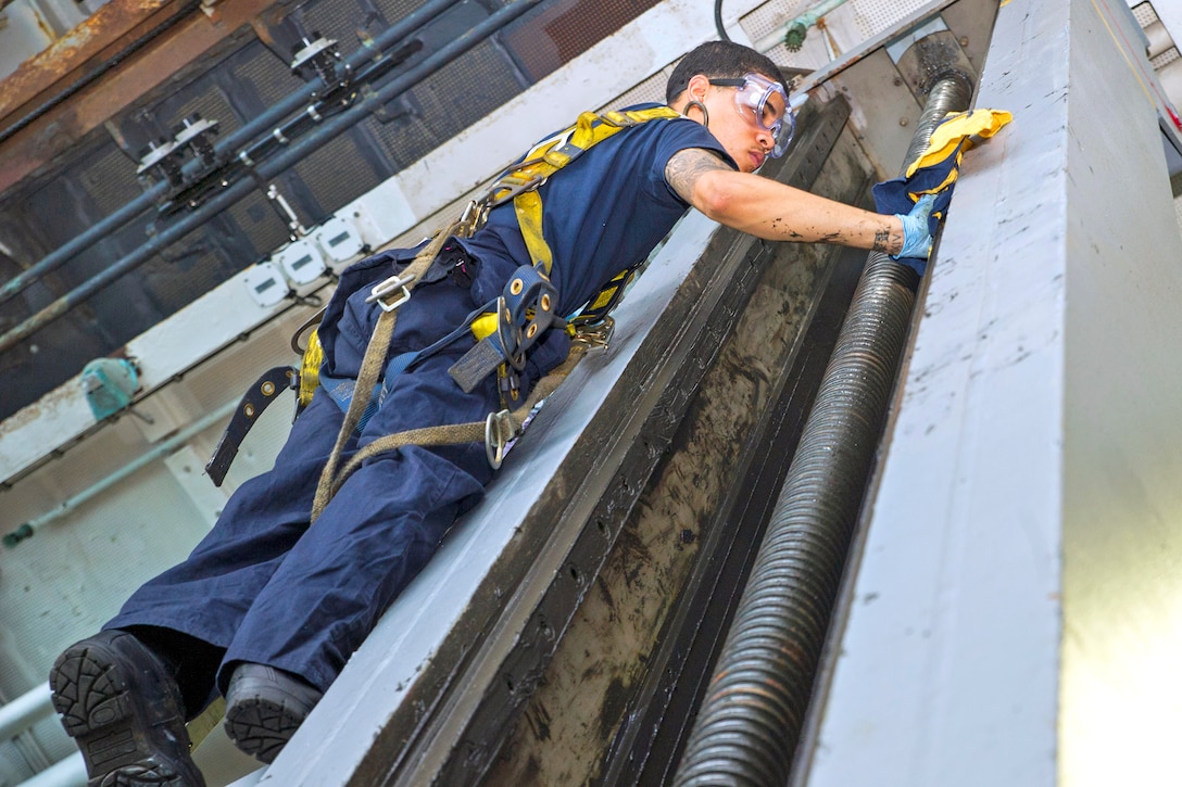 U.S. Navy Petty Officer 3rd Class Darius Haynes performs maintenance on a sliding padeye in the hangar bay of the Nimitz-class aircraft carrier USS George Washington, July 6, 2015. Haynes is a gas systems turbine technician (mechanical).