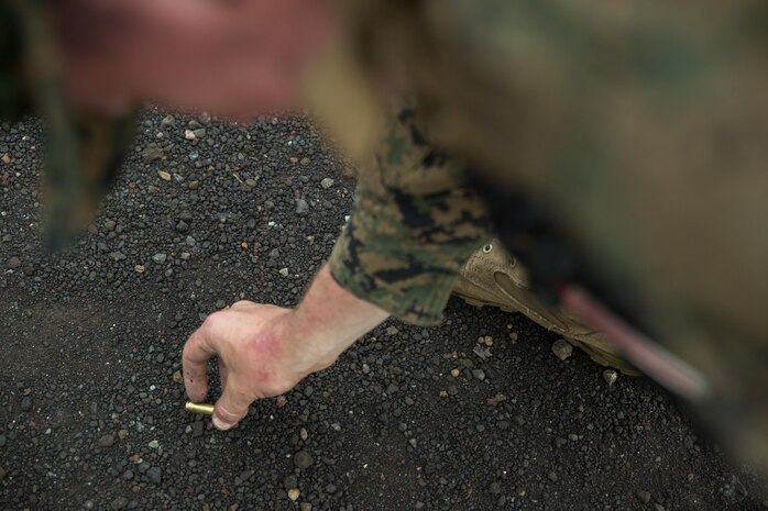Lance Cpl. Jesse Flanagan, an aviation ordinance technician with Headquarters and Headquarters squadron aboard Marine Corps Air Station Iwakuni, Japan, picks up 5.56mm ammo shells during Exercise Dragon Fire 2015, at Camp Fuji, Japan, July 14, 2015. CLC-36 uses the annual Dragon Fire exercise to keep the Marine’s basic riflemen skills refreshed and proficient.