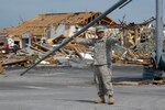 Pvt. First Class Jesus Ramos, 1139th Military Police Co., Missouri Army National Guard, directs traffic at a storm-damaged intersection near St. John’s Mercy Hospital in Joplin, Mo., on May 24, 2011. Ramos is part of a Guard contingent mobilized to assist local law enforcement with traffic control and other duties in the wake of the devastating tornado. Ramos said he just completed two weeks of state emergency flood duty in Mississippi County before being transferred here to assist with rescue and recovery efforts.