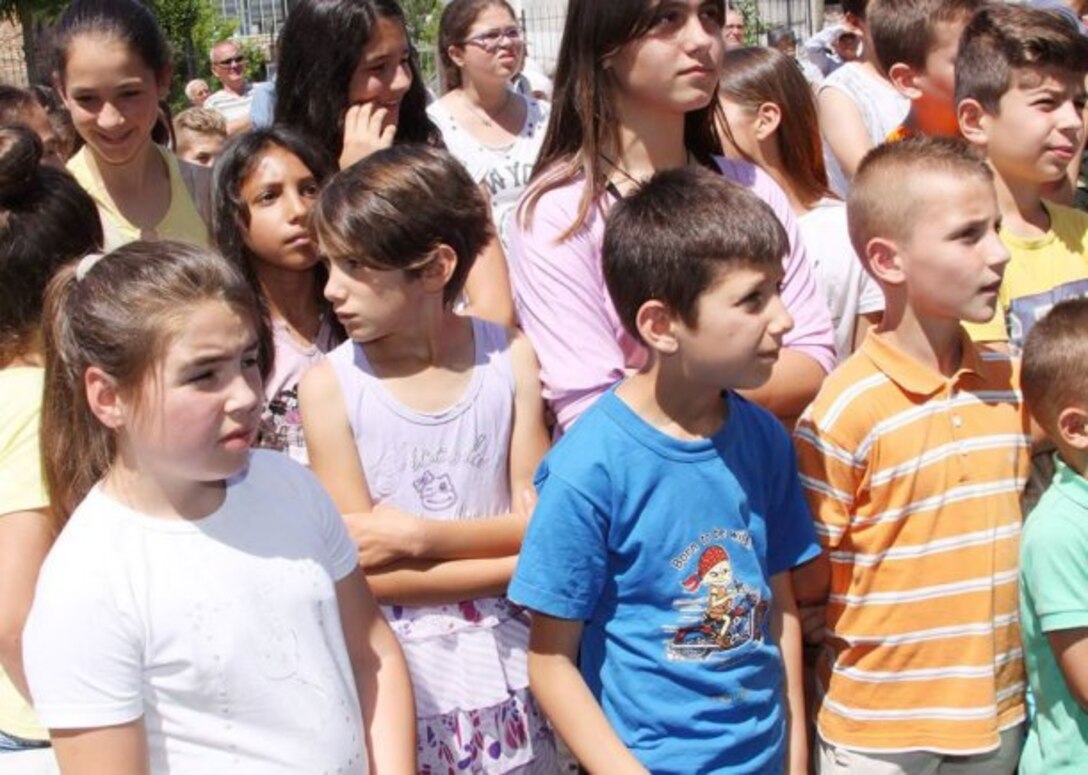 Local children assemble during the dedication and ribbon-cutting ceremony June 11 for their school in Kucove, Albania. Nearly 600 students ages 6-15 attend the "28 Nentori" facility, which was built in 1964 and had never been fully renovated.