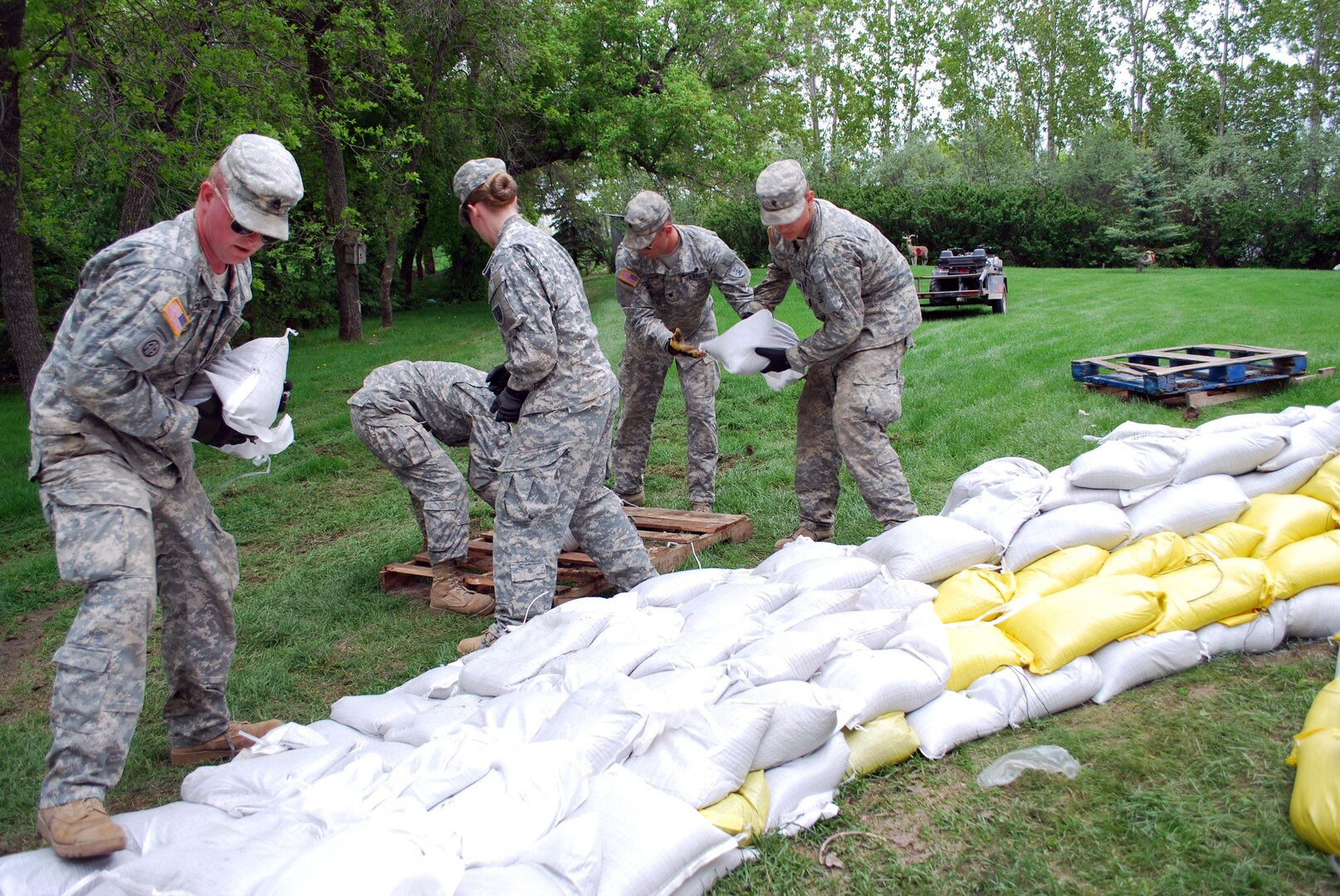 Staff Sgt. Walstad (left) and a group of Soldiers from the North Dakota National Guard's 957th Engineer Company (Multi-Role Bridge) and 814th Medical Company (Area Support) help build up a sandbag dike for a homeowner along Nordic Lane in Bismarck, N.D., June 2, 2011.