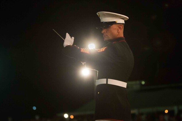 Gunnery Sgt. Daniel Sullivan, conductor, U.S. Marine Corps Forces, Pacific Band, conducts the music during a military tattoo in Nuku'alofa, Tonga, July 8, 2015. The band supported the king of Tonga's coronation ceremonies alongside Tonga's Royal Corps of Musicians, the Australian Army Band and the New Zealand Army Band. (U.S. Marine Corps photo by Cpl. Brittney Vito/Released)