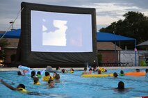 Children and adults watch “How to Train Your Dragon 2” from the pool during the Flick and Float event at the 50m pool July 9.