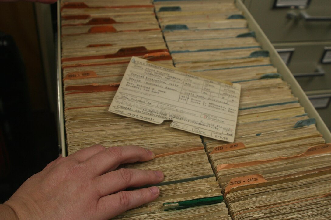 Annette Amerman, historian in the historical reference branch, examines old Marine casualty cards, July 13, Marine Corps Base Quantico. Based at Marine Corps University aboard Quantico, the division writes about the history from documents collected by the archives department.